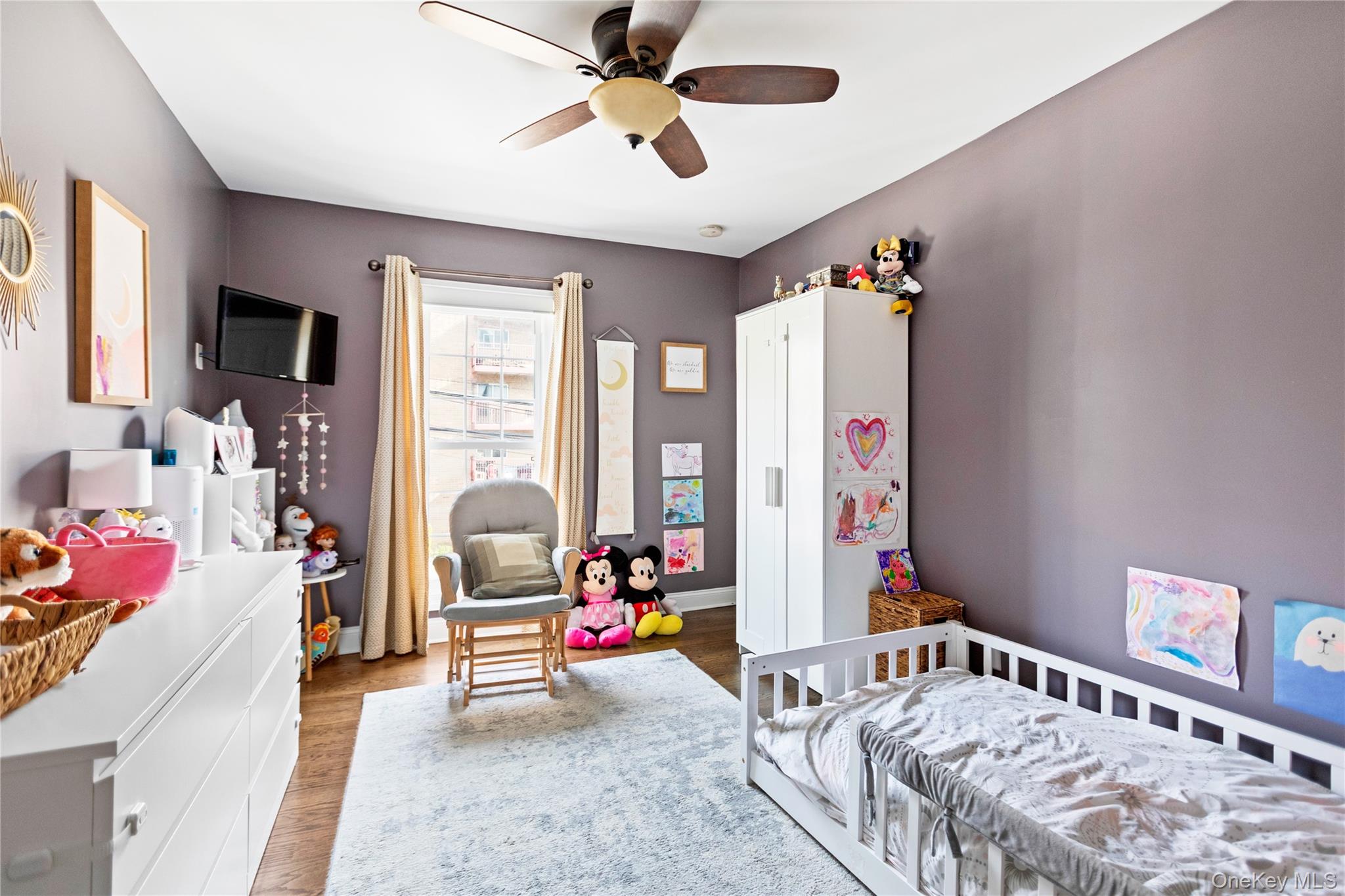 10 Maple Avenue Patchogue, NY 11772 - Photo 25 of 28 Bedroom with wood finished floors, a nursery area, and a ceiling fan