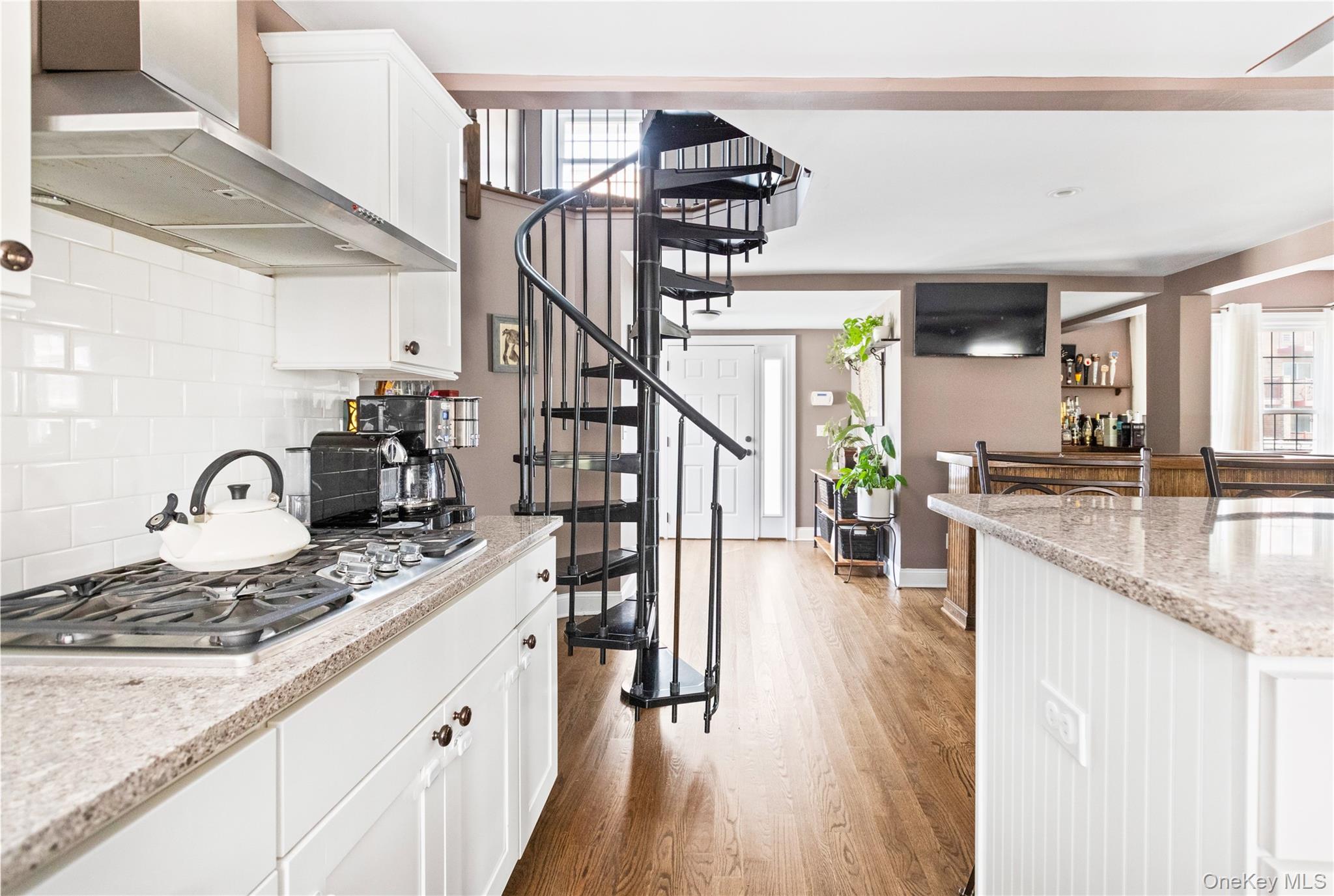 10 Maple Avenue Patchogue, NY 11772 - Photo 4 of 28 Kitchen featuring wall chimney exhaust hood, white cabinetry, plenty of natural light, and light wood-style flooring