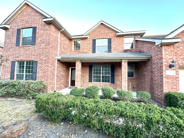 front view of a brick house with a small yard