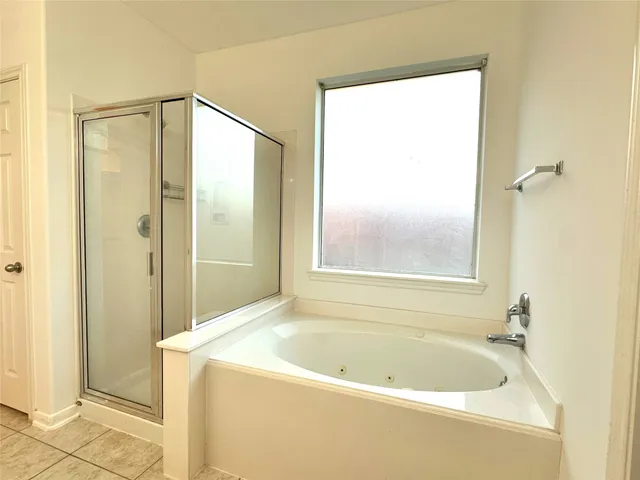 an empty room with wooden floor and ceiling fan