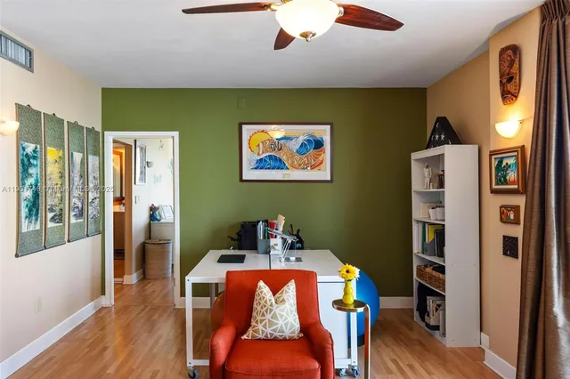 a living room with furniture a bookshelf and a window