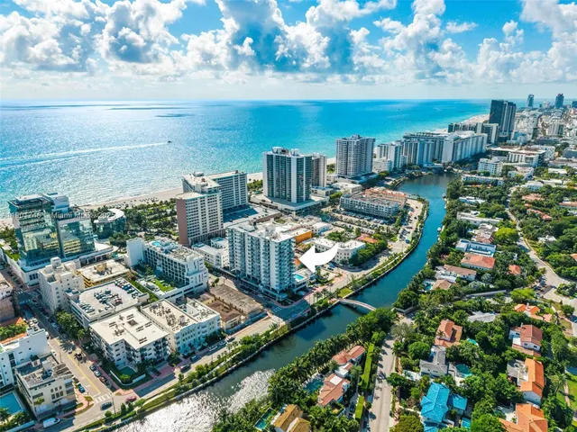 a view of swimming pool with lawn chairs and plants