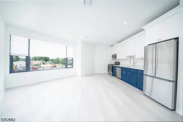 a large kitchen with a large window and stainless steel appliances