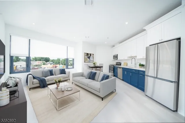 a living room with furniture white walls and white appliances