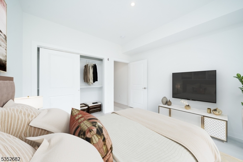 12 River Road, Unit 303 Fair Lawn, NJ 07410 - Photo 4 of 16 a hotel room with a bed and a flat screen tv