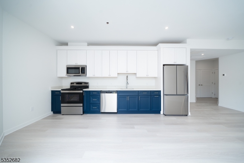 12 River Road, Unit 303 Fair Lawn, NJ 07410 - Photo 10 of 16 a kitchen with stainless steel appliances a refrigerator a stove a sink a window and white cabinets
