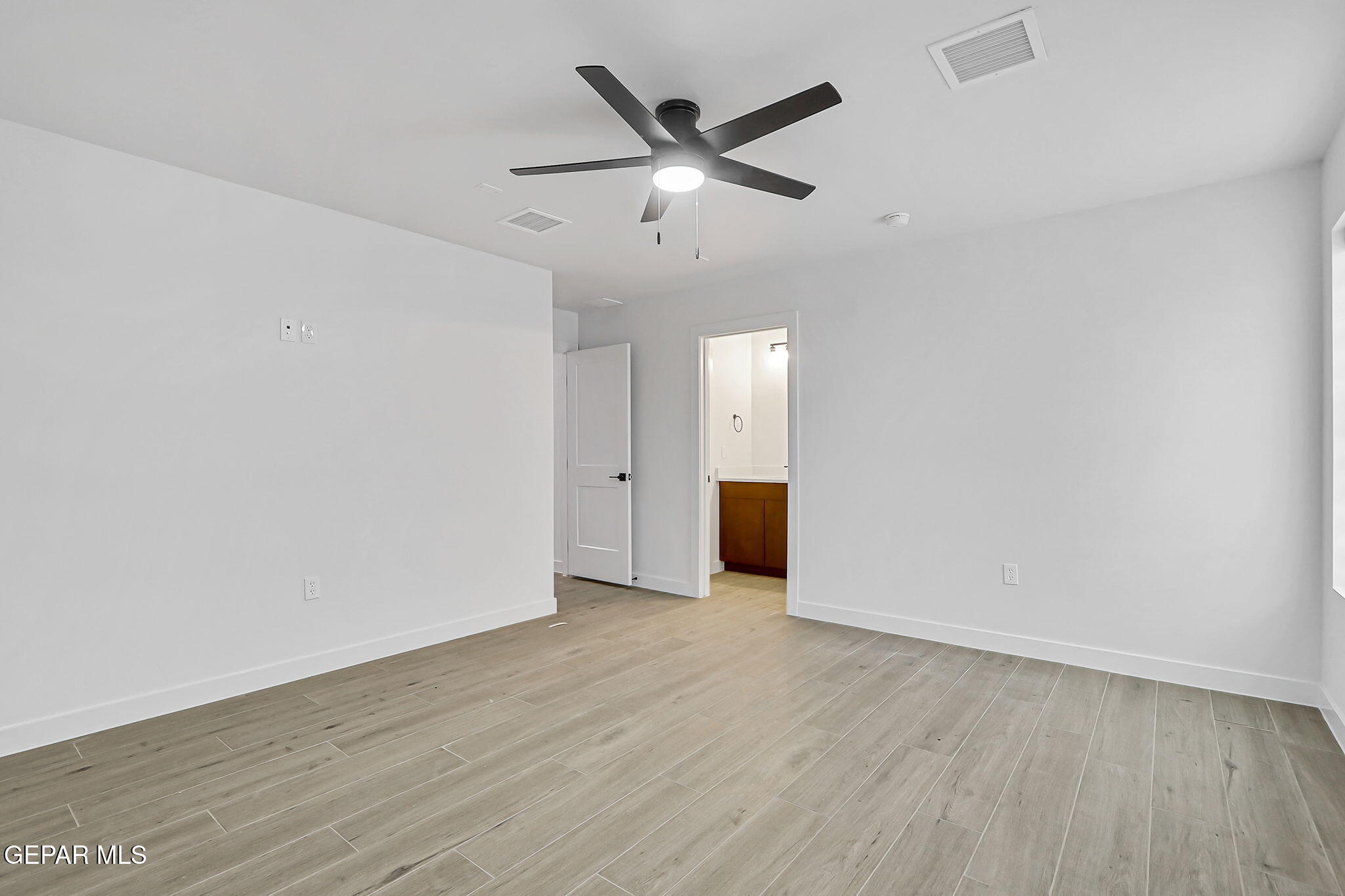 5981 Ruidoso Downs Street El Paso, TX 79932 - Photo 18 of 35 an empty room with wooden floor ceiling fan and windows