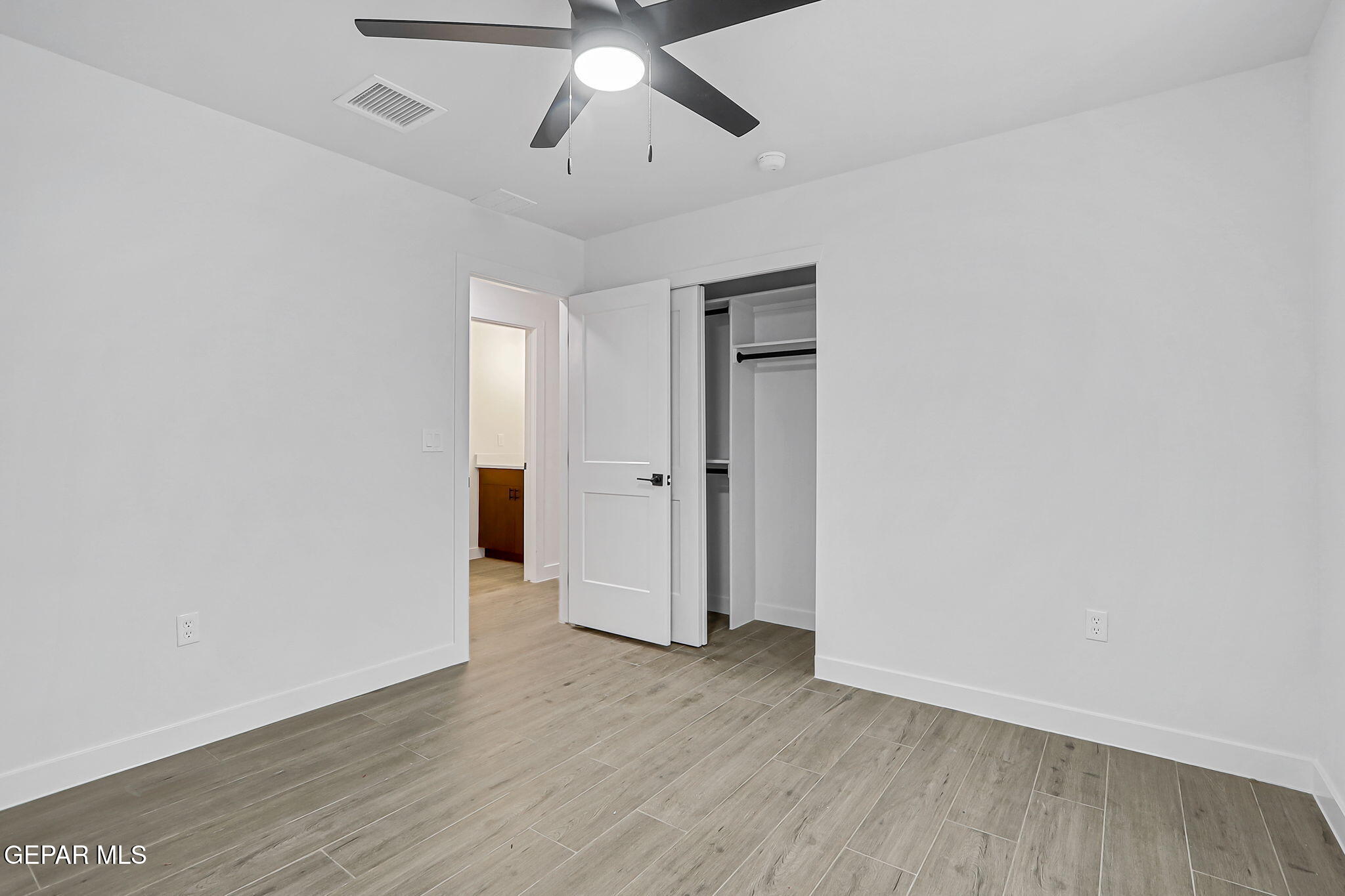 5981 Ruidoso Downs Street El Paso, TX 79932 - Photo 24 of 35 an empty room with wooden floor and ceiling fan