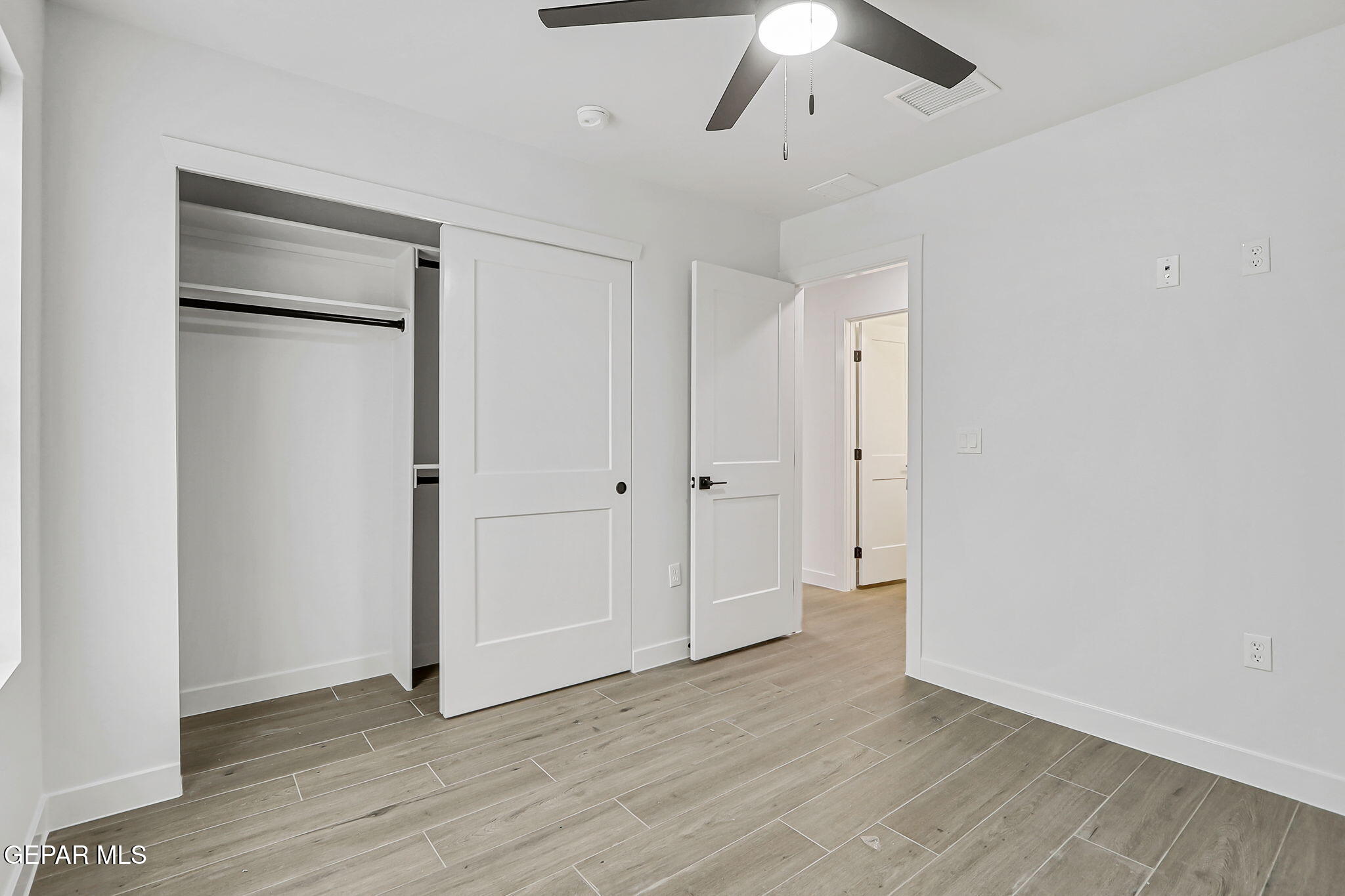 5981 Ruidoso Downs Street El Paso, TX 79932 - Photo 30 of 35 an empty room with wooden floor a ceiling fan