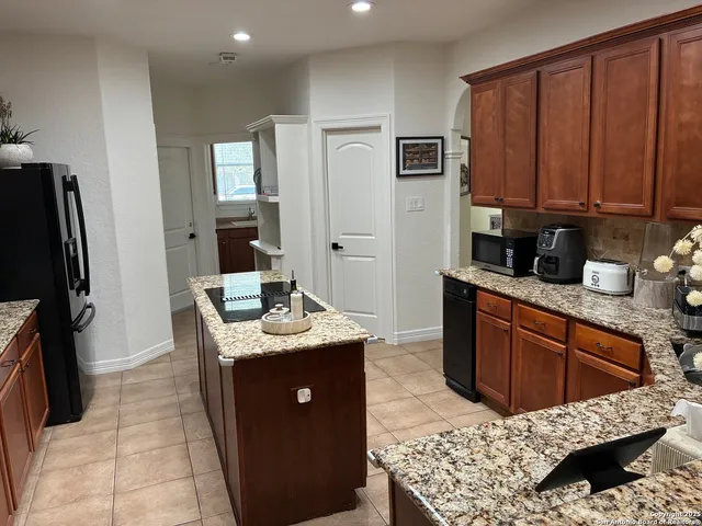 a kitchen with stainless steel appliances kitchen island granite countertop a sink stove and refrigerator