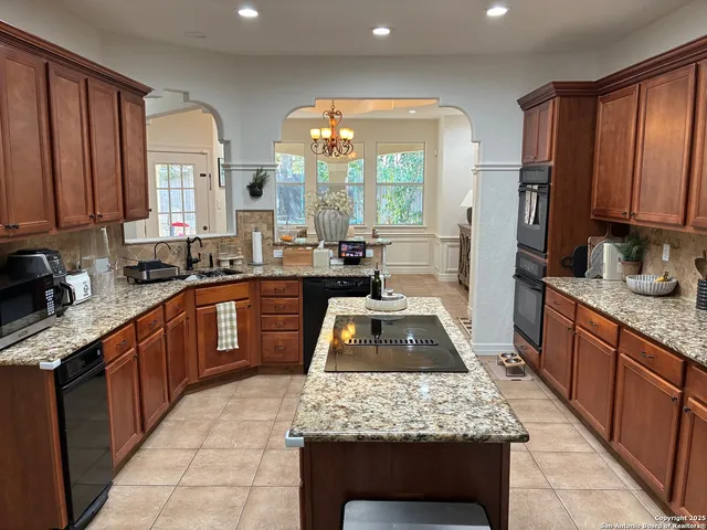 a kitchen with stainless steel appliances granite countertop wooden cabinets a stove top oven a sink and dishwasher