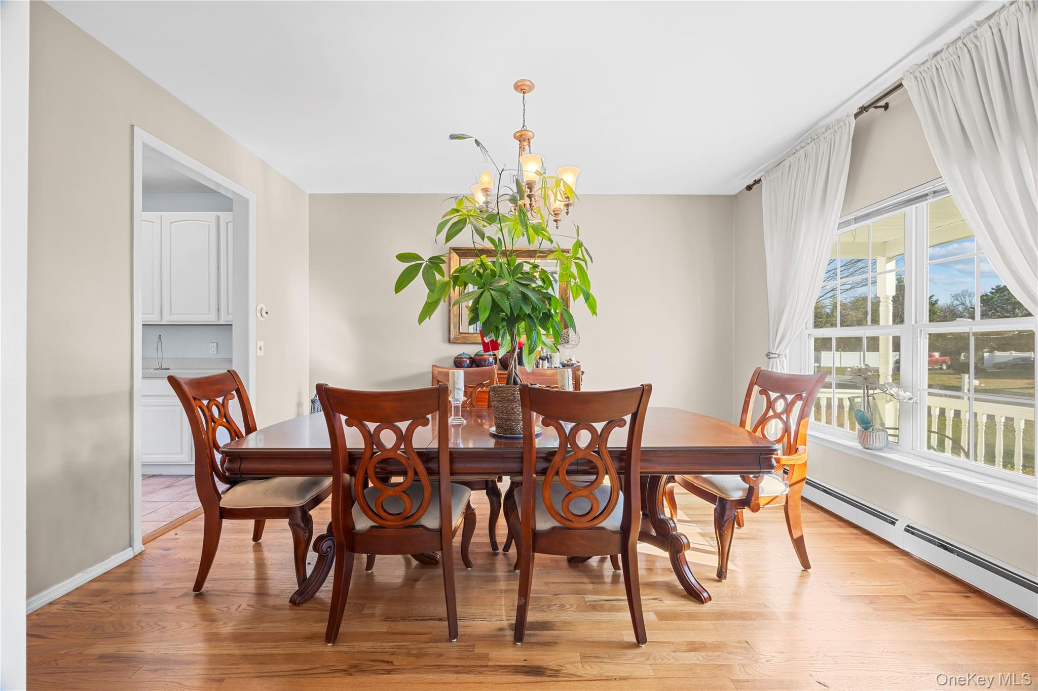 7 Bittersweet Lane Center Moriches, NY 11934 - Photo 11 of 32 a dining room with furniture potted plants and wooden floor