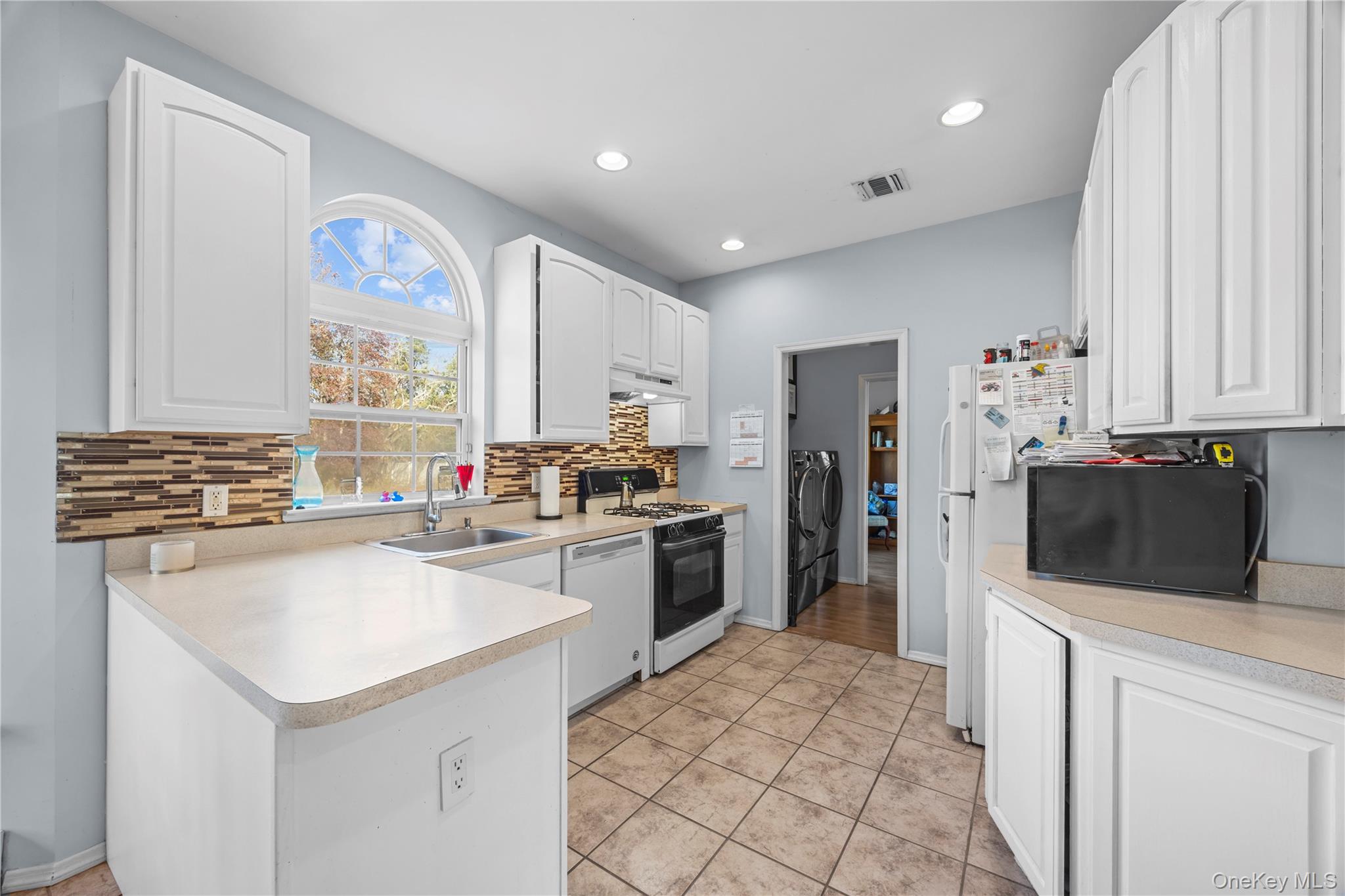 7 Bittersweet Lane Center Moriches, NY 11934 - Photo 14 of 32 a kitchen with a sink stove and refrigerator