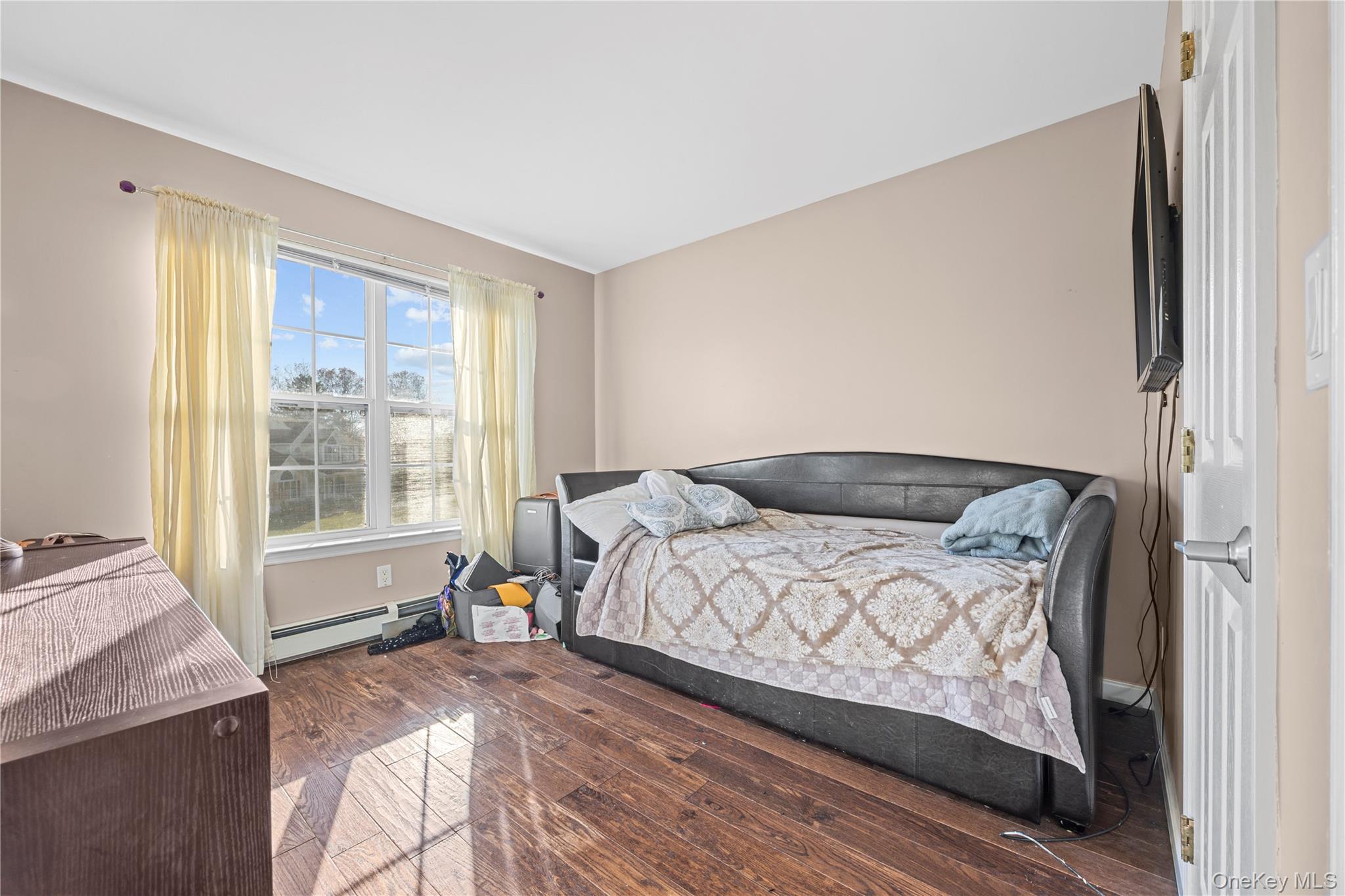 7 Bittersweet Lane Center Moriches, NY 11934 - Photo 29 of 32 a bedroom with a large bed and wooden floor