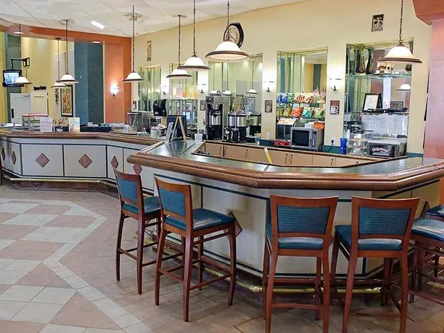 a dining hall with chairs and view kitchen