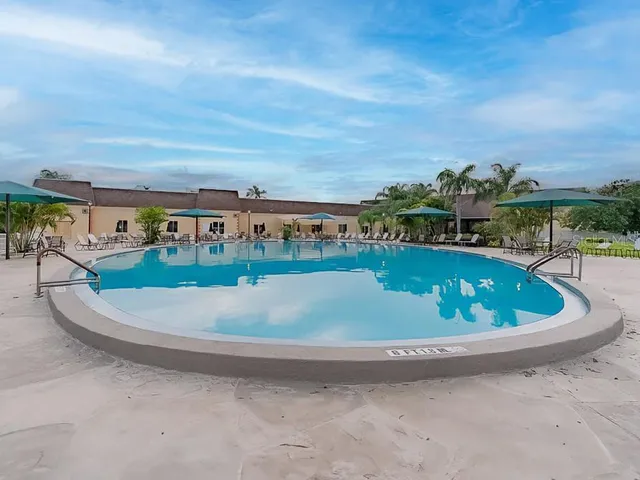 a view of a swimming pool with lawn chairs
