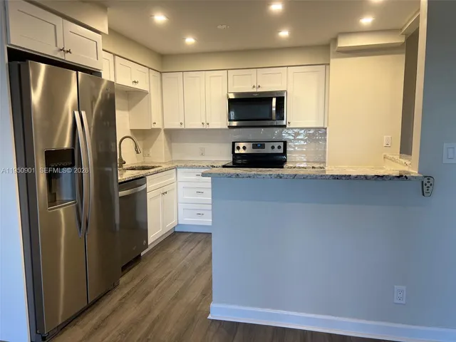 a kitchen with stainless steel appliances a refrigerator stove microwave and sink