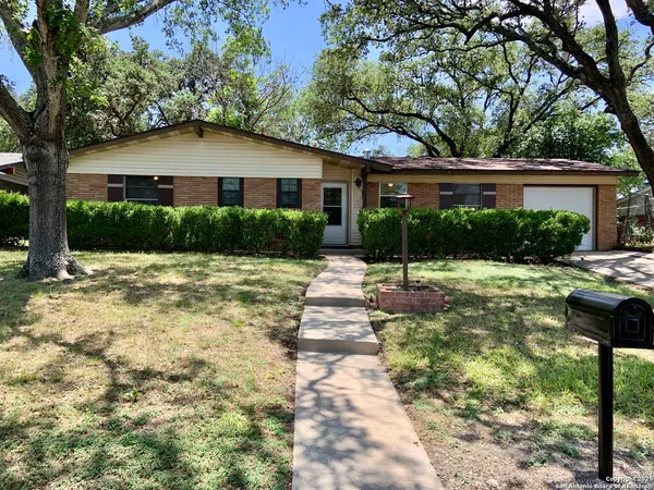 a front view of a house with a yard and plants