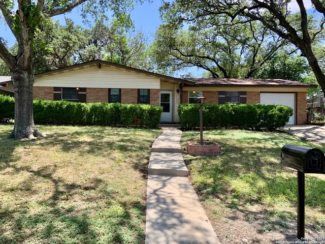 a front view of a house with a yard and plants