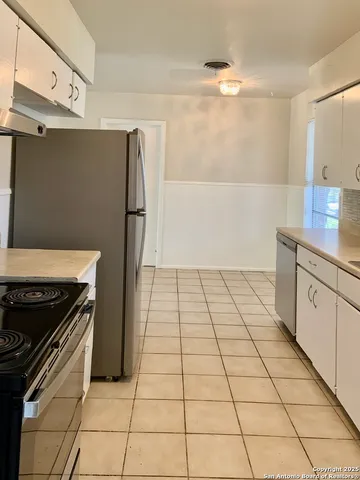 a kitchen with a stove a refrigerator and cabinets