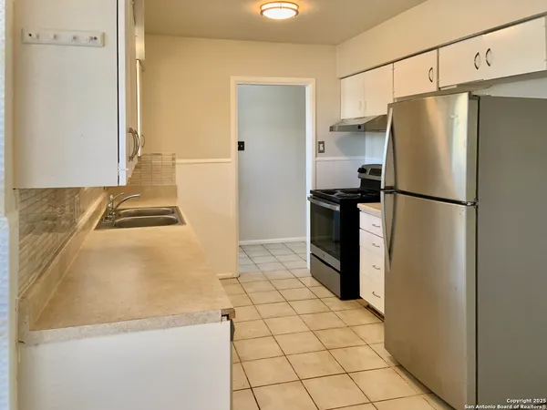 a white refrigerator freezer and a stove sitting inside of a kitchen