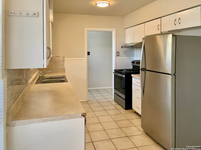 a white refrigerator freezer and a stove sitting inside of a kitchen