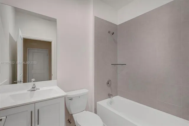 a large white kitchen with kitchen island a sink stainless steel appliances and a counter top