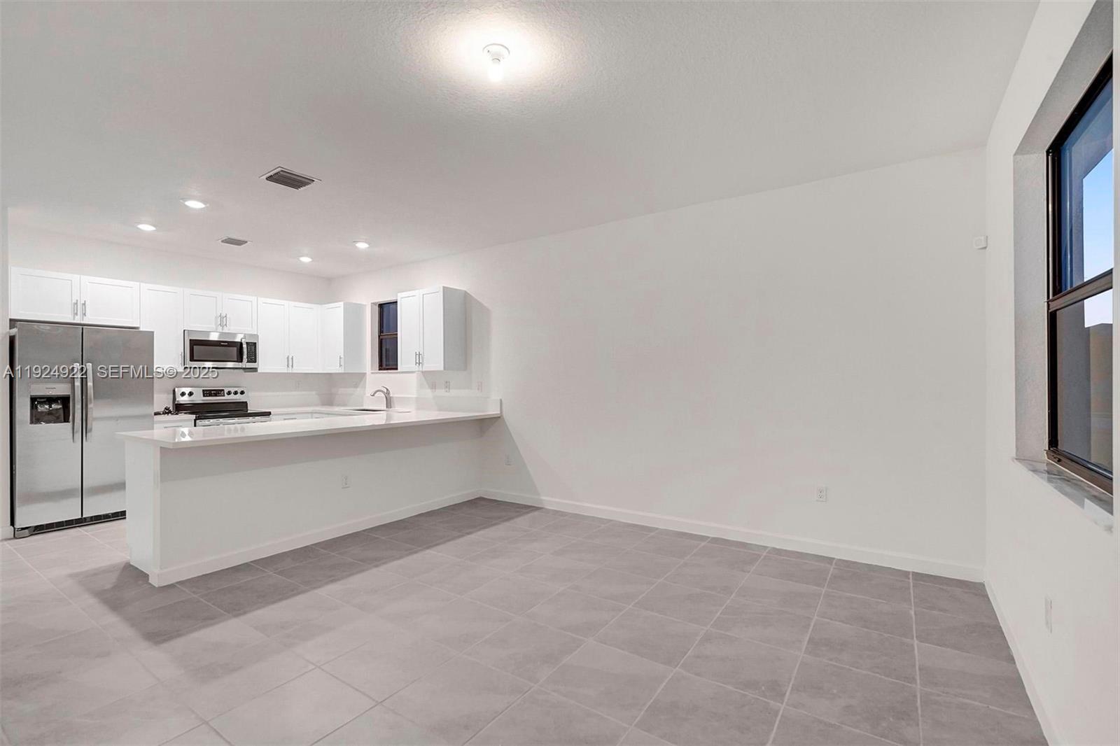 13405 Southwest 285th Street, Unit 13405 Homestead, FL 33033 - Photo 5 of 59 a large white kitchen with white cabinets and a refrigerator