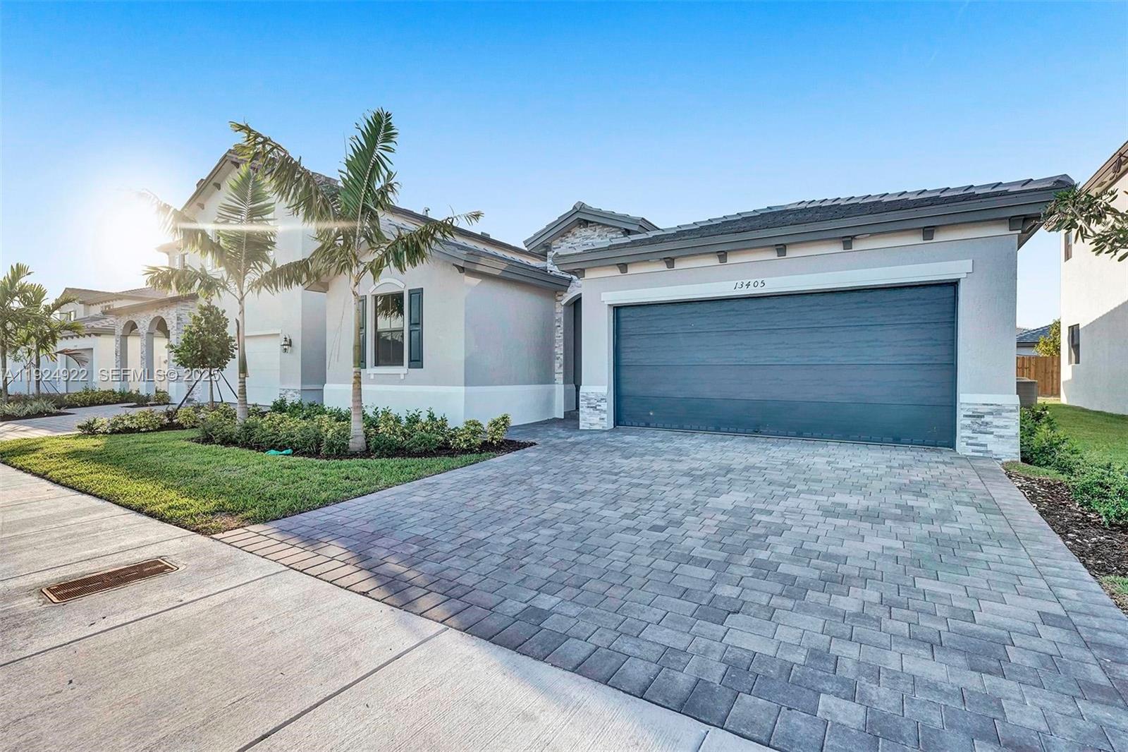 13405 Southwest 285th Street, Unit 13405 Homestead, FL 33033 - Photo 59 of 59 a front view of a house with a yard and garage