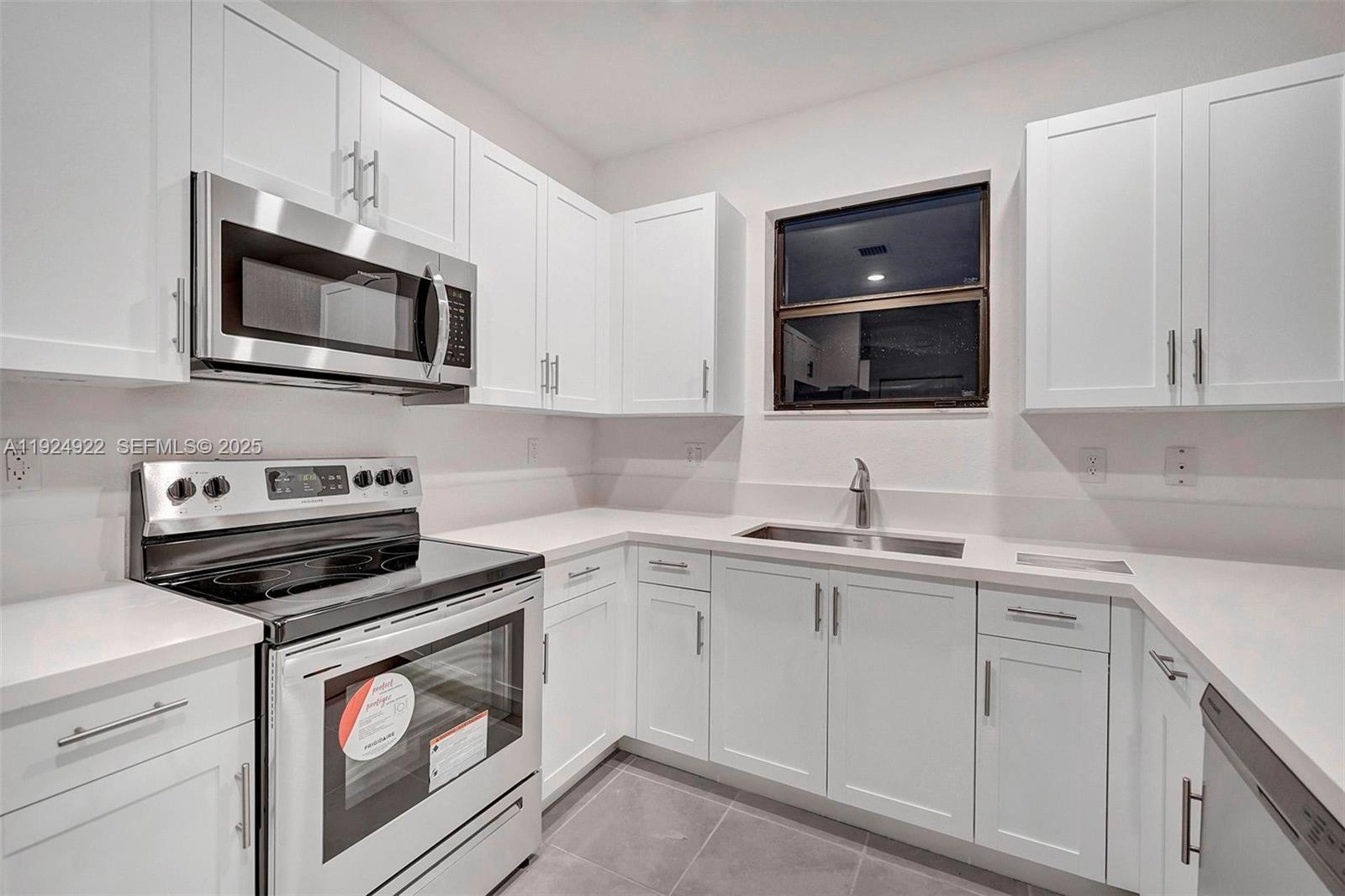 13405 Southwest 285th Street, Unit 13405 Homestead, FL 33033 - Photo 7 of 59 a kitchen with white cabinets stainless steel appliances and sink