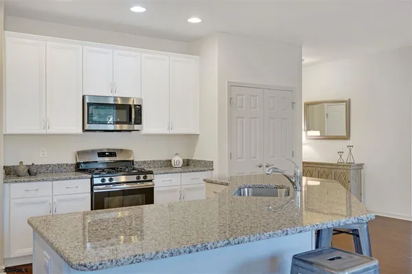 a kitchen with stainless steel appliances granite countertop a stove a sink and a microwave