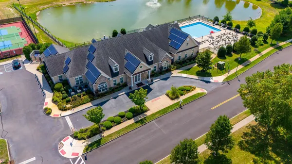 an aerial view of a house with a garden and lake view
