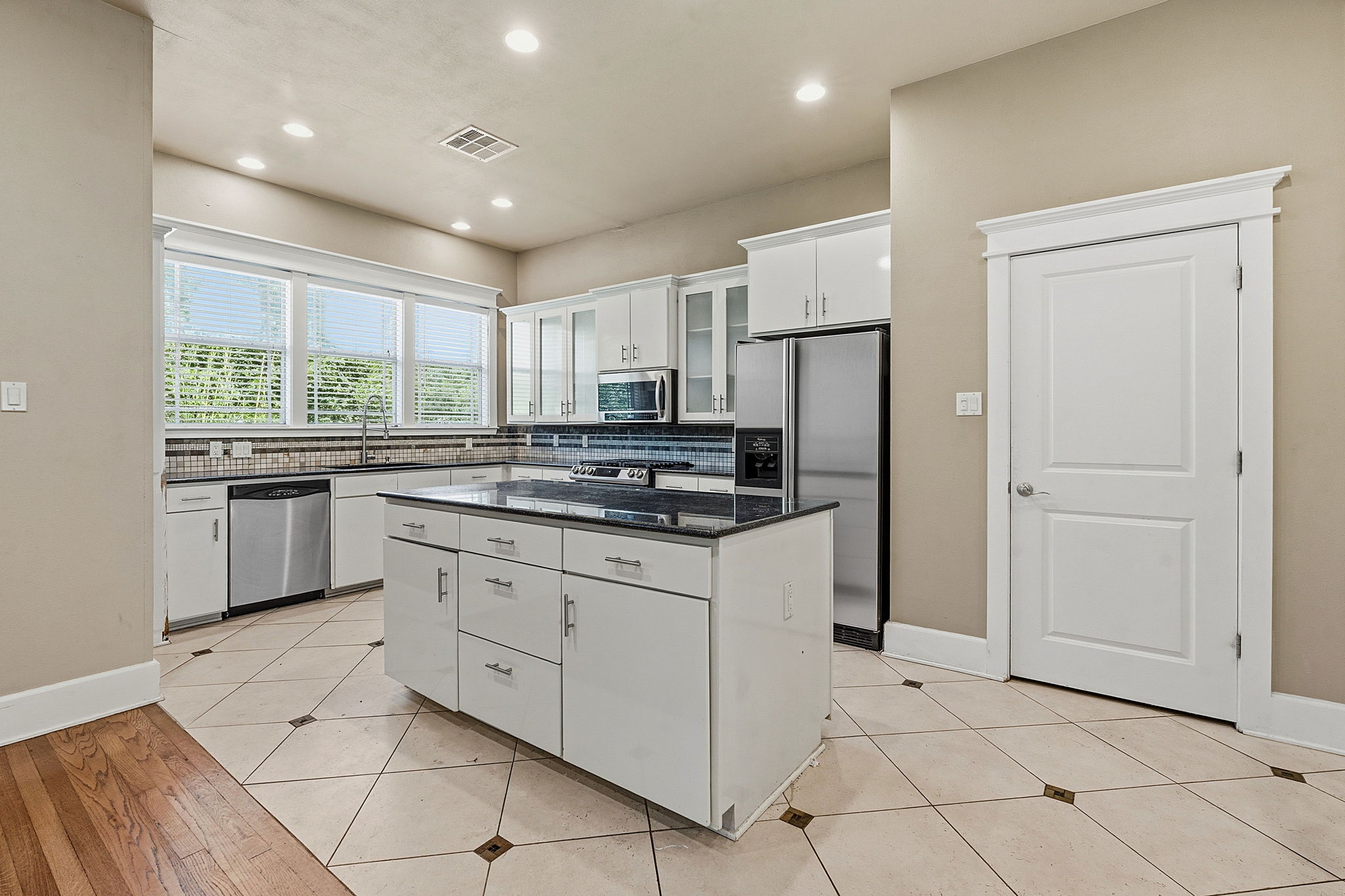1305 Cometa Street Austin, TX 78721 - Photo 5 of 28 A well-equipped kitchen features a central island, plentiful cabinetry, and contemporary stainless steel appliances.