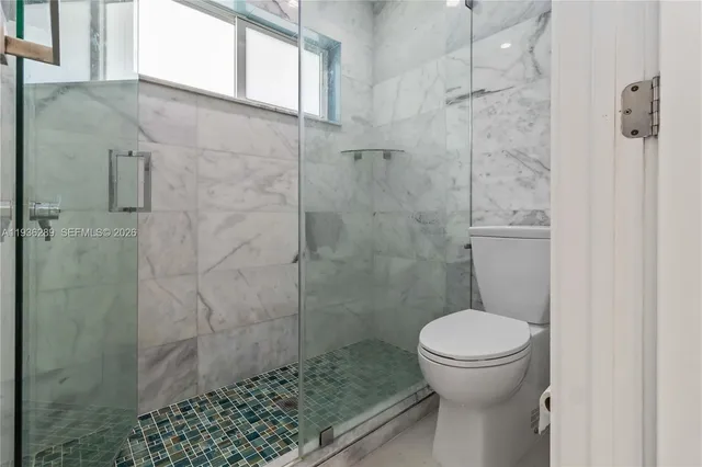 a bathroom with a toilet and a shower