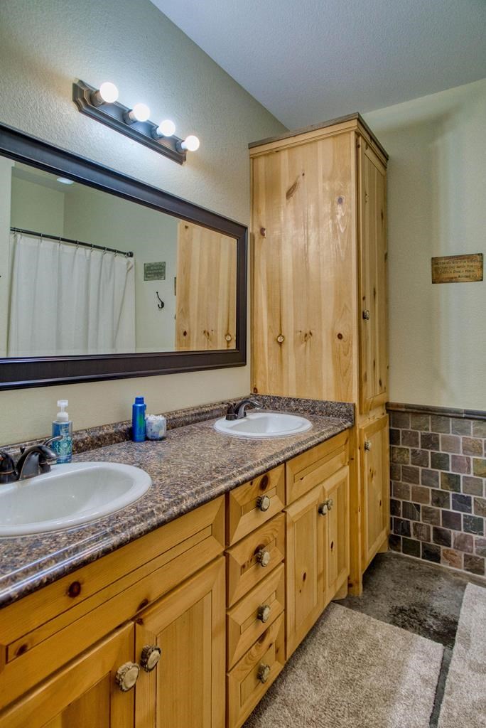 6446 Blackjack Road Fredonia, TX 76842 - Photo 34 of 48 a bathroom with a granite countertop sink and a mirror