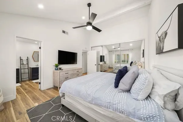 a large bedroom with a bed and a flat screen tv