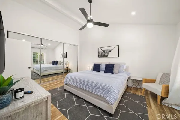 a bedroom with a bed a mirror and lamp