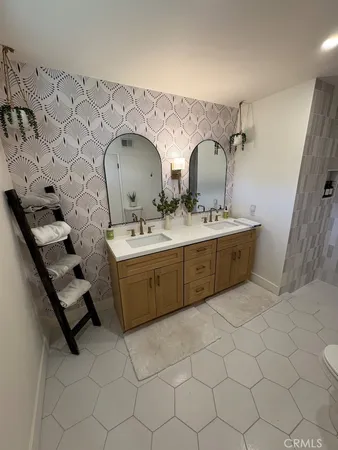 a en suite bathroom with a double vanity sink and mirror