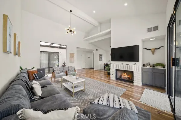 a living room with furniture a fireplace and a flat screen tv