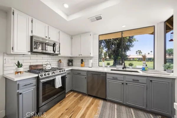 a kitchen with stainless steel appliances granite countertop a stove a sink and cabinets