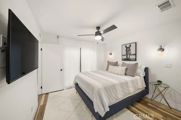 a bedroom with bed tv and a window