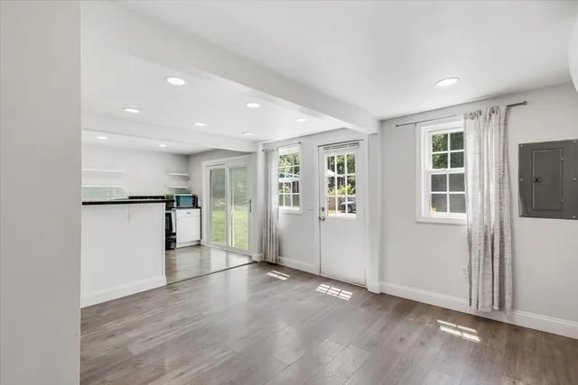 an empty room with wooden floor and windows