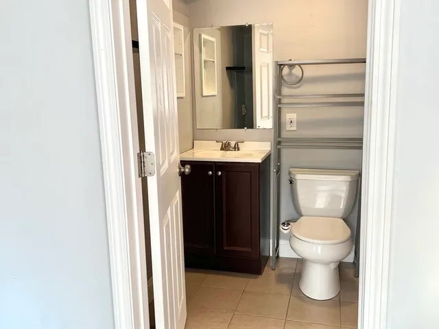 a bathroom with a granite countertop toilet and a sink