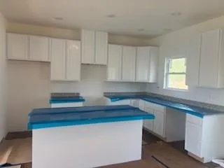 a kitchen with stainless steel appliances a sink dishwasher a stove and white cabinets with wooden floor