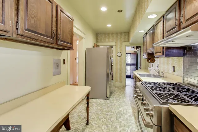 a kitchen with refrigerator and chairs