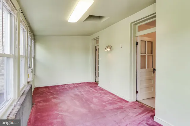 a view of a room with wooden floor and a window