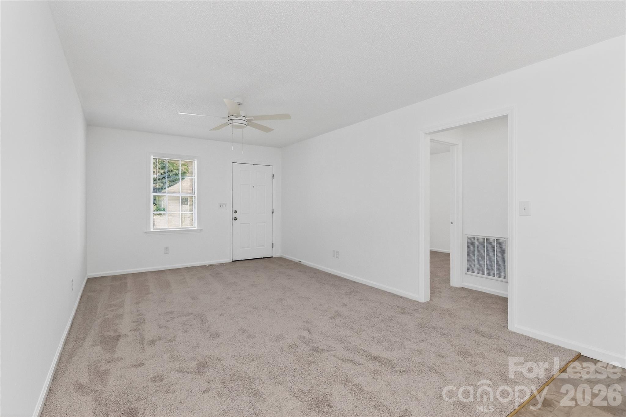 91-93 Sunderland Road Southwest, Unit 93 Concord, NC 28027 - Photo 7 of 30 an empty room with a ceiling fan and window