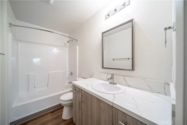 a bathroom with a granite countertop sink toilet a large mirror and shower