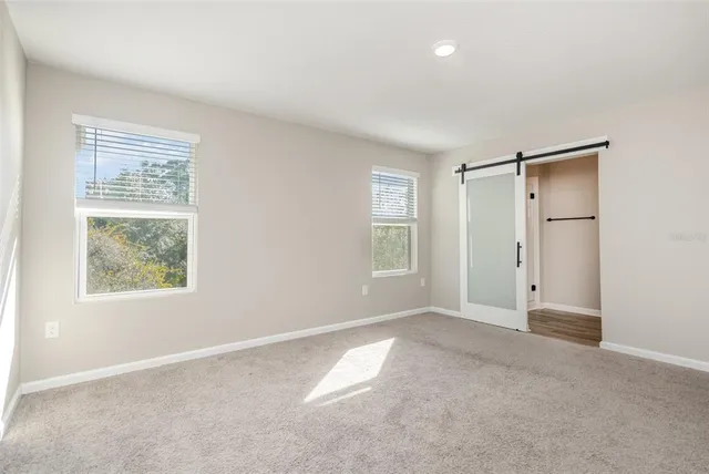 an empty room with windows and closet