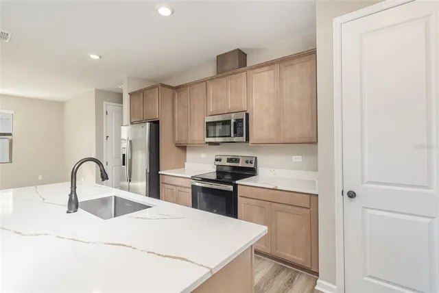 a kitchen with stainless steel appliances a refrigerator sink and cabinets